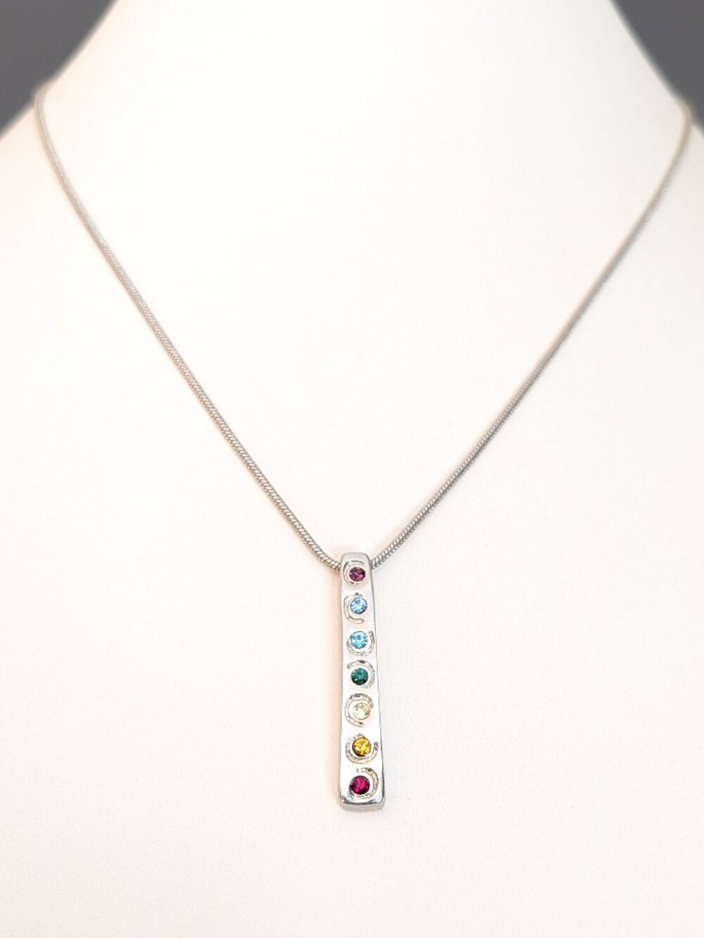 Silver tone pendant necklace with multi colored cz's